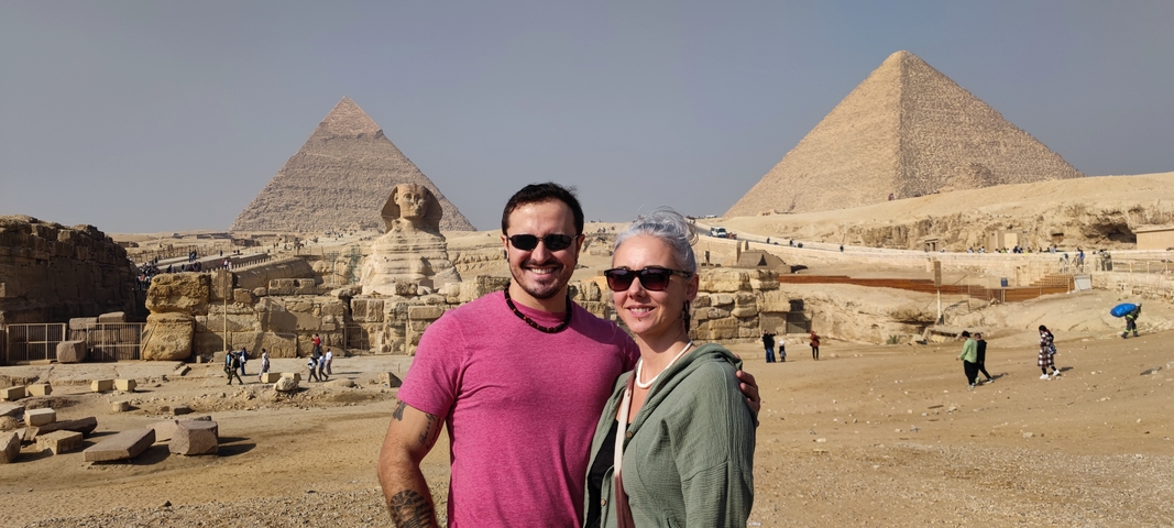 Couple posing with the Pyramids and the Sphinx in the background.