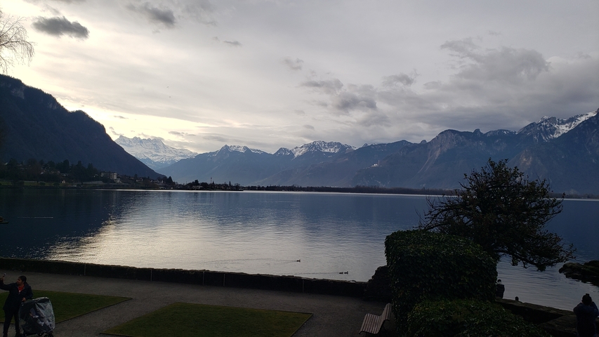 Lake view with mountains in the distance and a cloudy sky.