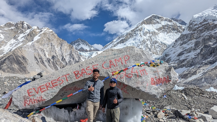       Two people posing at Everest Base Camp with mountains
  