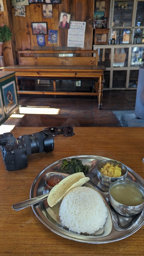 Table with a camera and a traditional Nepali meal