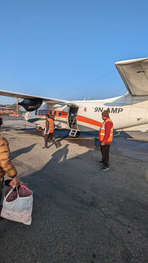       Small aircraft with people boarding at an airport
  