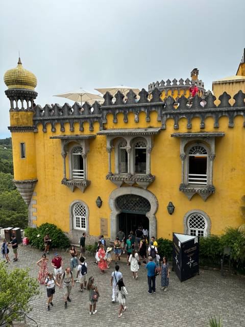 A group of tourists outside a colorful historical building.