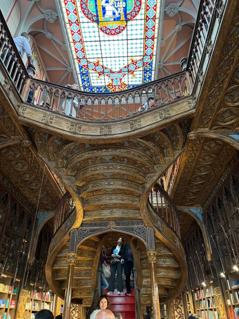 An ornate interior staircase with stained glass windows.
