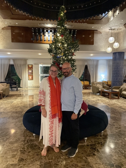 Couple standing in a hotel lobby decorated for the holidays