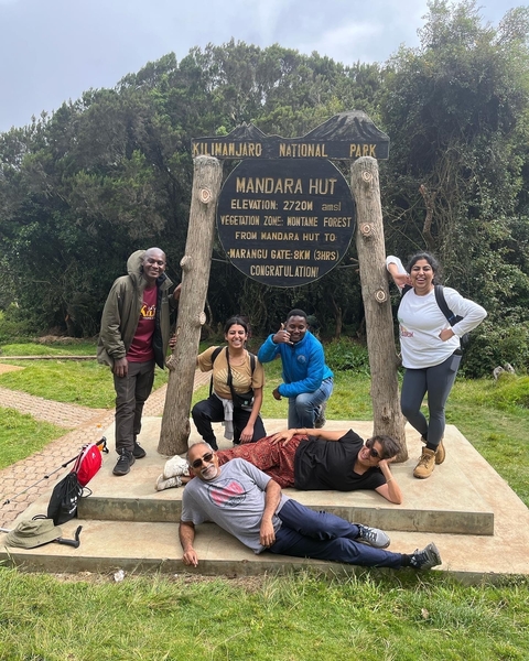 Group of people posing with a sign at a hiking checkpoint