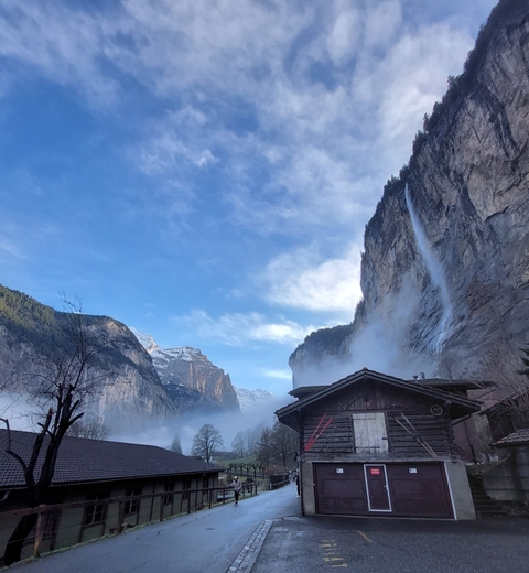       Waterfall cascading from a tall rocky cliff.
  