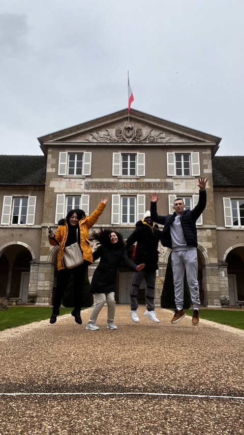       Group of people jumping outside a building.
  