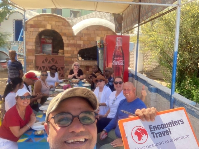 Group eating outdoors with a sign saying 'Encounters'.