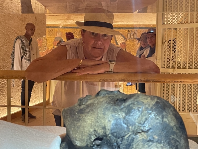 Tourist inside a tomb with ancient paintings.