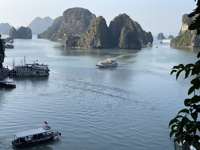       Landscape of a bay with boats and limestone formations.
  