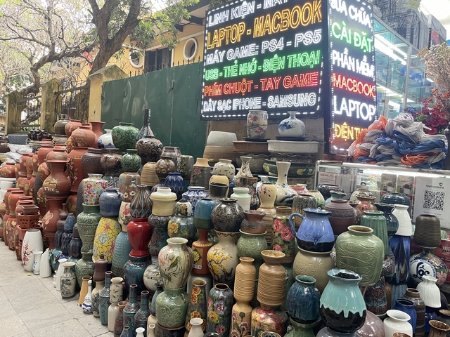       Colorful array of ceramic vases displayed on the street.
  