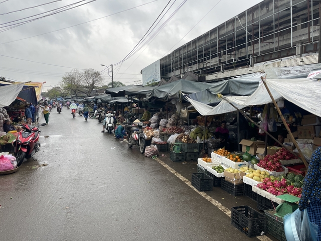       Busy outdoor market with vendors and shoppers.
  