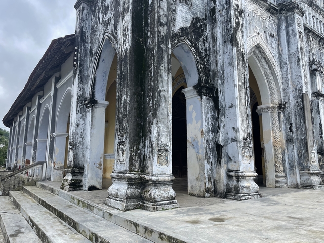       Old temple facade with moss-covered stonework.
  