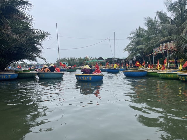       People paddling traditional basket boats with flags.
  