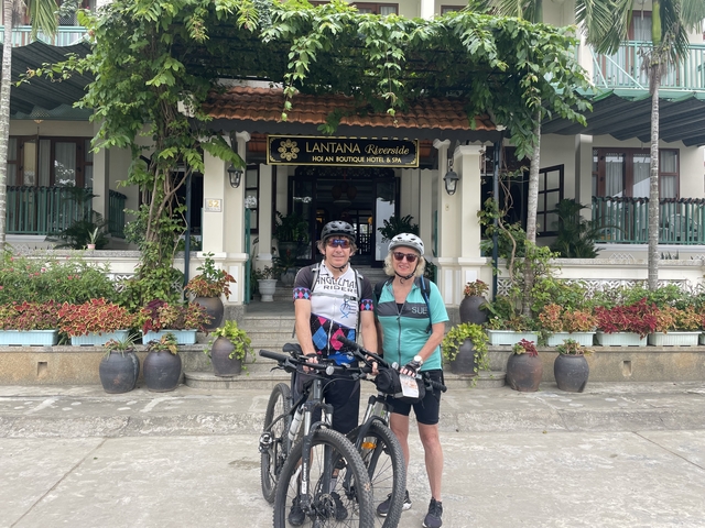       Cyclists outside a hotel entrance.
  