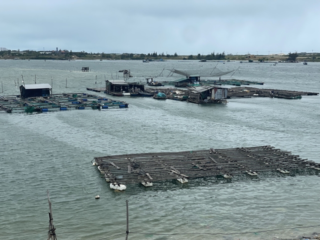       Floating fishing platforms on a river.
  