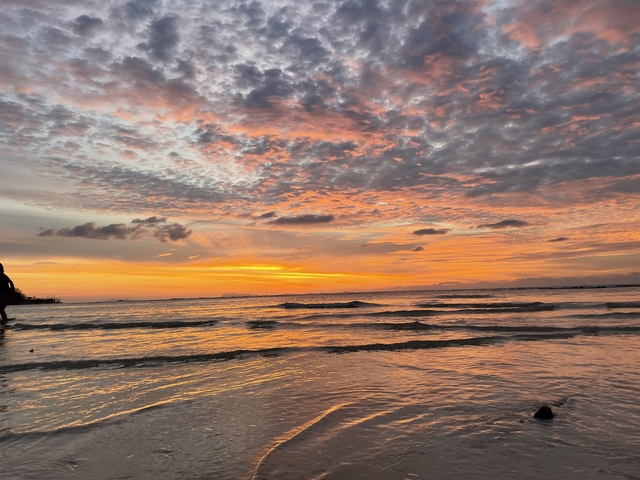 A stunning sunset over the ocean with vibrant clouds.