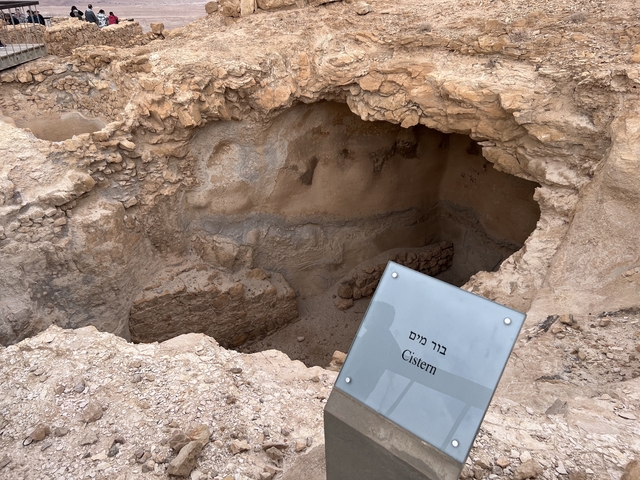      Archaeological cistern site with information plaque.
  