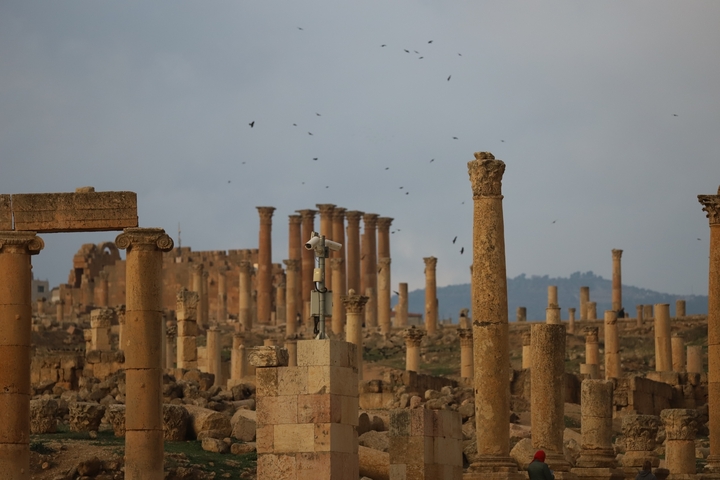       Ruins with ancient columns and distant hills.
  