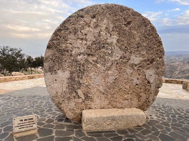       Large stone disk displayed on a paved area with an informative plaque.
  
