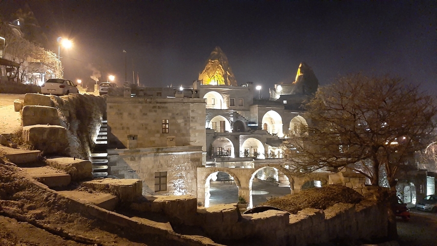       Night scene showing illuminated rock architecture with an ancient feel.
  