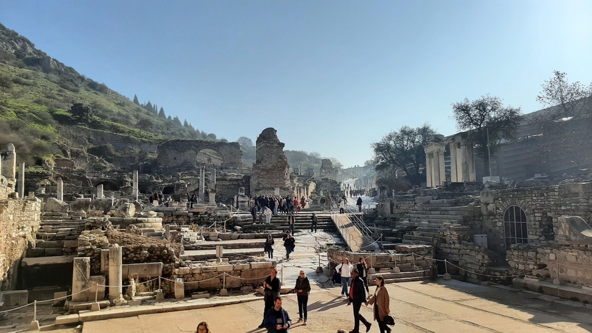       Crowded ruins with tourists exploring the ancient site.
  