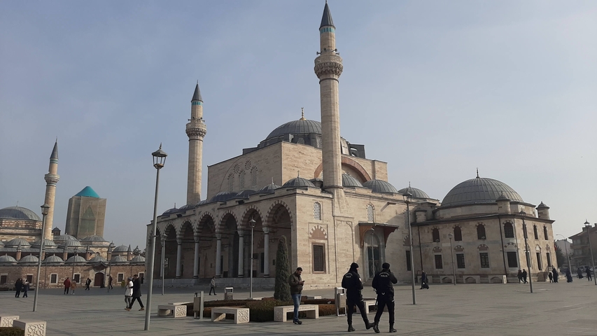       Large mosque with multiple domes and minarets under a clear sky.
  