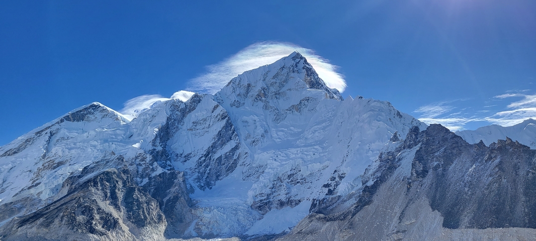       Sharp snow-covered peaks under a bright blue sky.
  