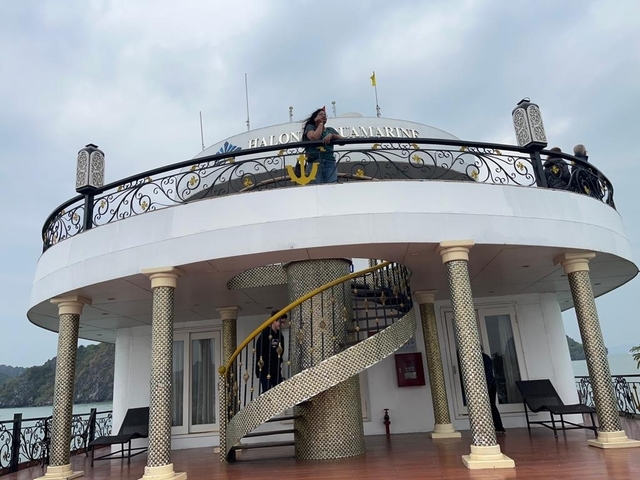       Person on the deck of a boat named 'Halong Jasmine'.
  