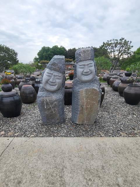 Stone sculptures of figures with smiling faces.