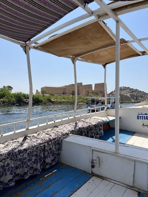       Boat deck view with a riverside temple in the distance.
  