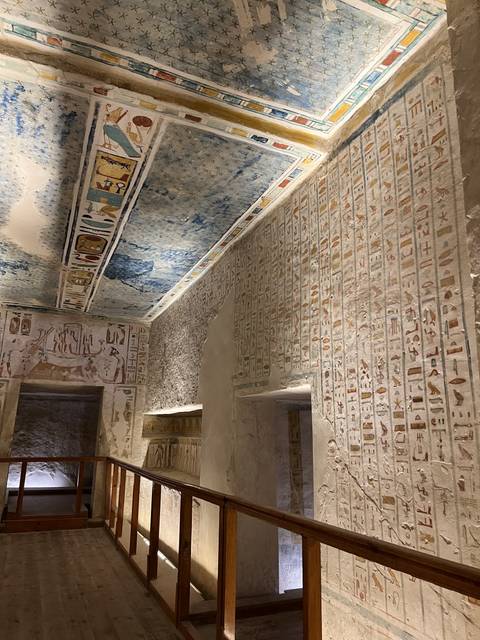 Interior of an ancient tomb with vibrant wall paintings.