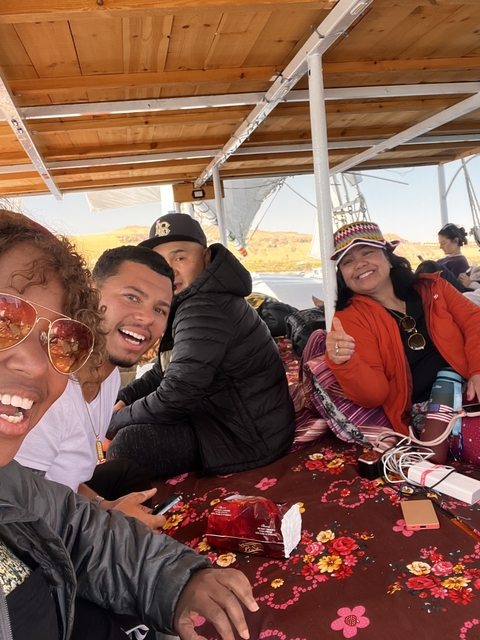       People on a boat in a scenic area enjoying the view.
  