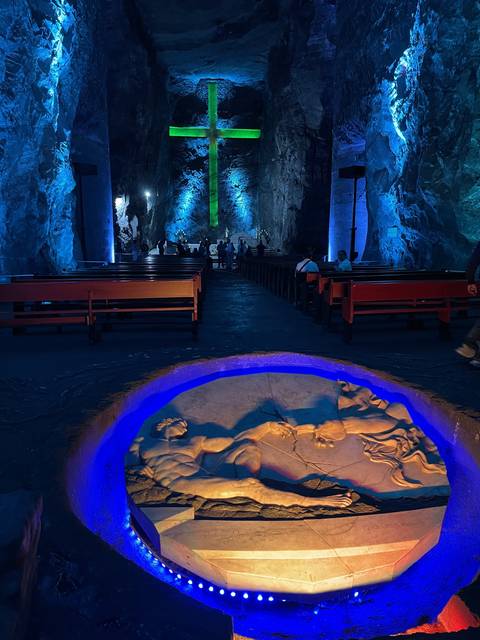       Underground church with large cross lit in green
  