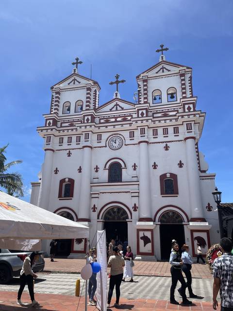       Ornate church facade with people standing in front
  