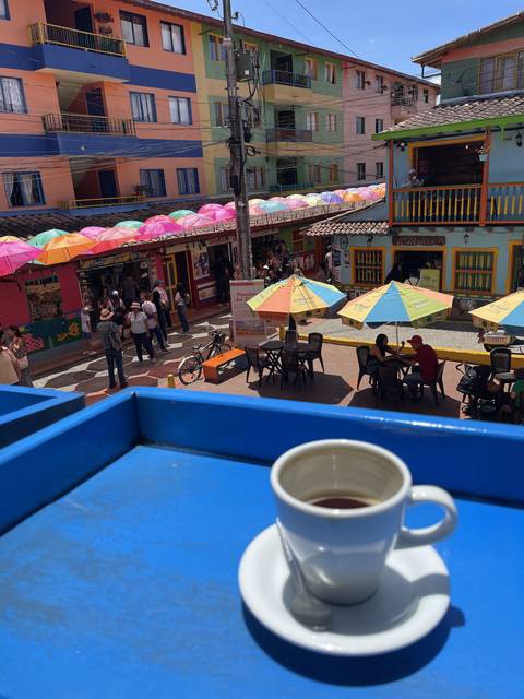       Colorful street cafe with people and tables
  
