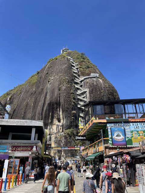       Rock hill with stairs and people climbing
  