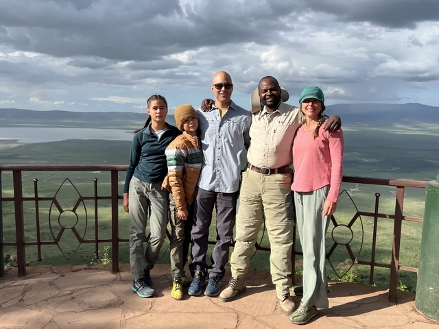       Group of people overlooking a vast African landscape.
  