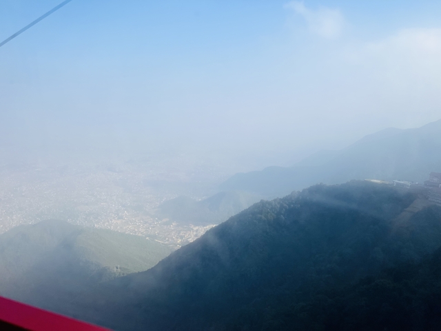       Hazy view of mountains and a city below.
  