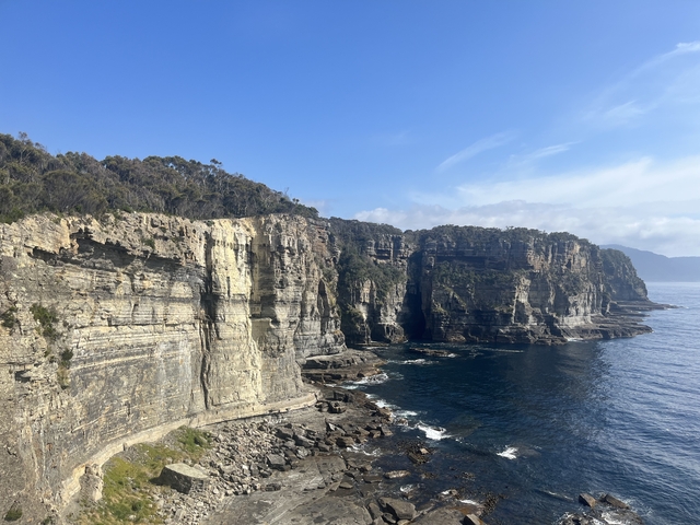 Cliffs overlooking the ocean with clear skies in Tasmania.