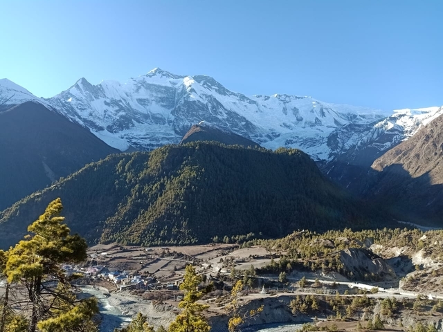 Majestic mountains with snow and a green valley below.