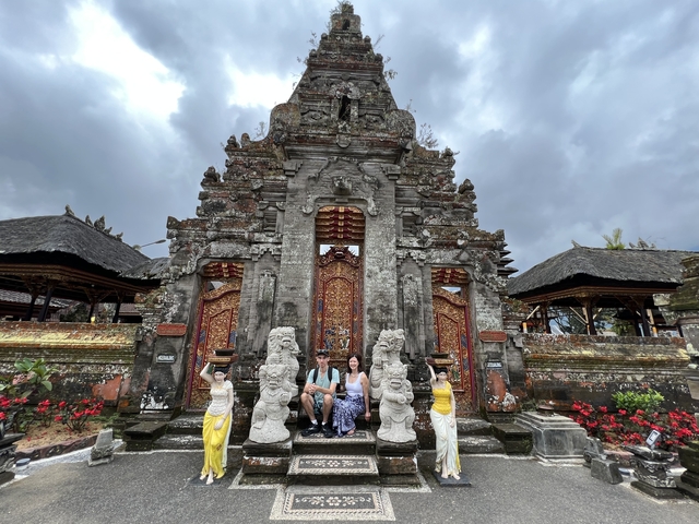       Group of people in traditional attire in front of a temple entrance.
  