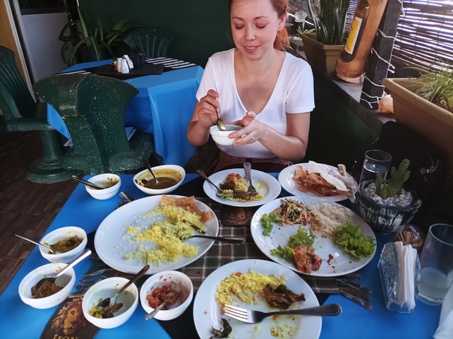 Person having a meal at a table filled with various dishes.