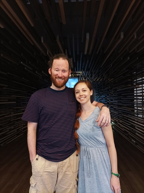       Couple smiling and posing indoors.
  