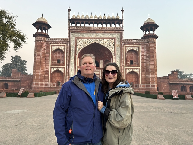       Couple posing in front of a historic gate.
  