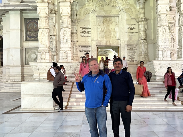       People posing inside a marble temple.
  