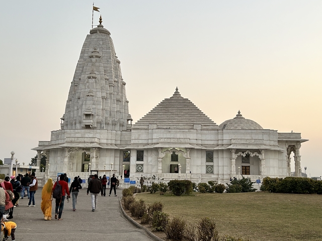       White marble temple with visitors outside.
  