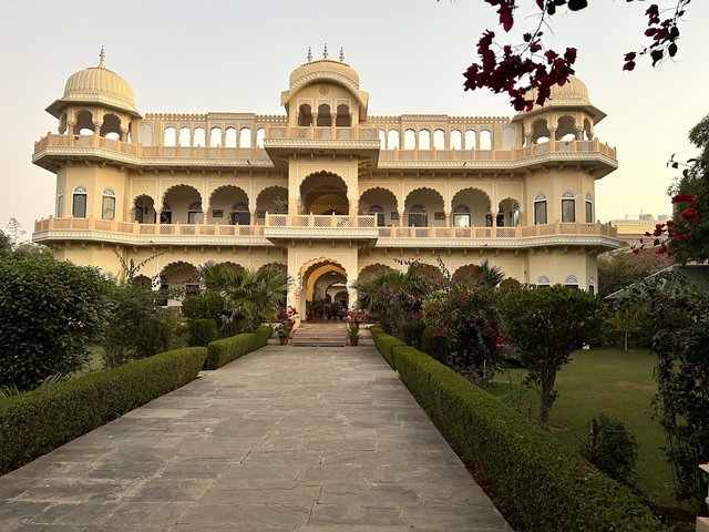       Elegant heritage building with a garden pathway.
  