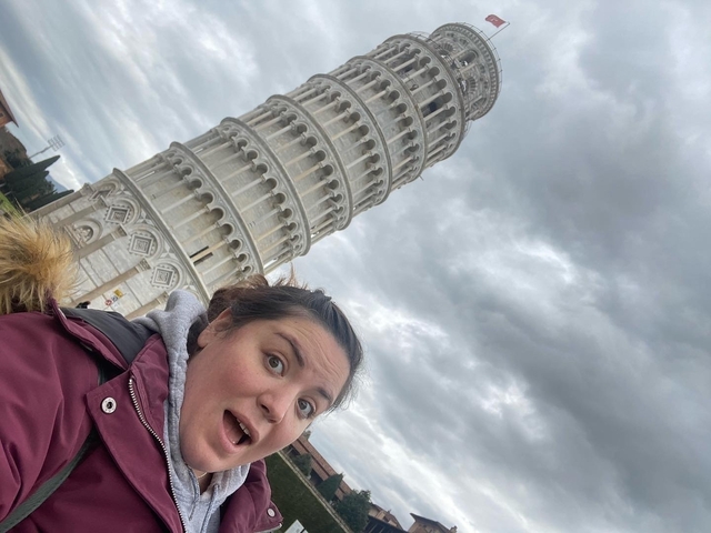       Person posing in front of the Leaning Tower of Pisa.
  