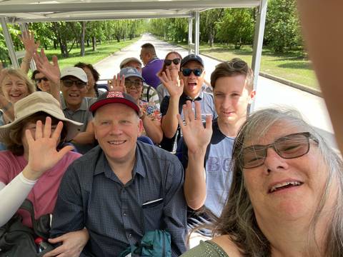 A group photo of people waving at the camera.
